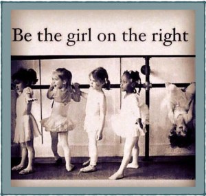 Line of girls in ballet class where the girl on the right hangs by her knees from the barre while other students stand on their feet.