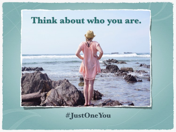 Woman stands on beach and contemplates the view.