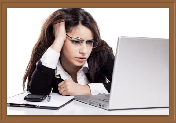 Woman stares in confusion at computer screen.