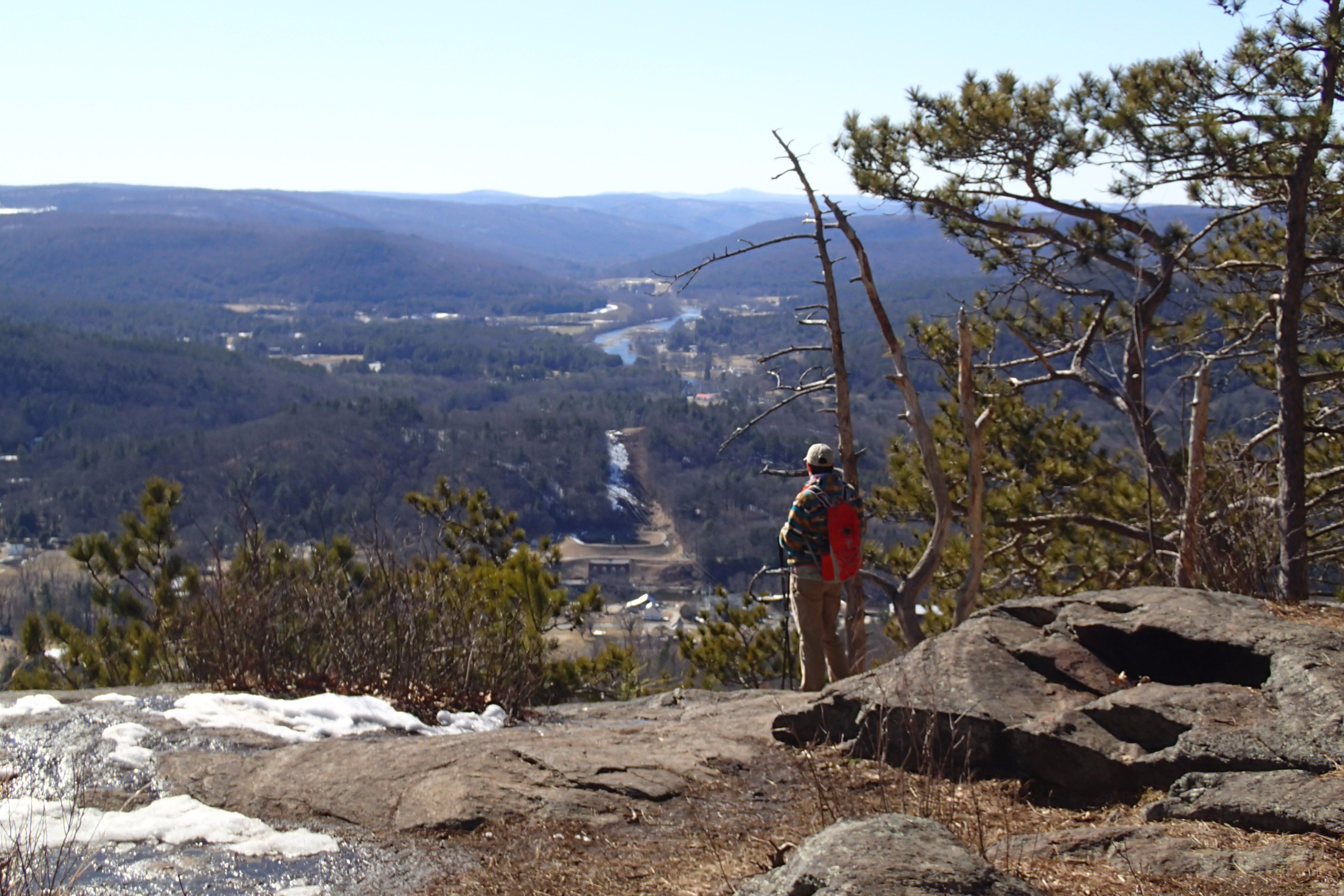 Woman overlooks a river valley and mountains.