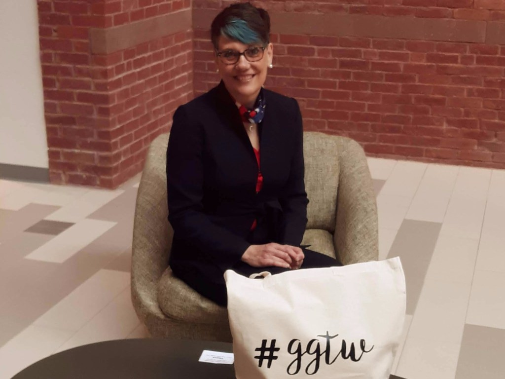 Tricia Yacovone-Biagi seated at a table with the GGTW swag bag.