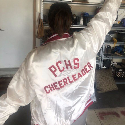 Woman wearing jacket that reads PCHS CHEERLEADER